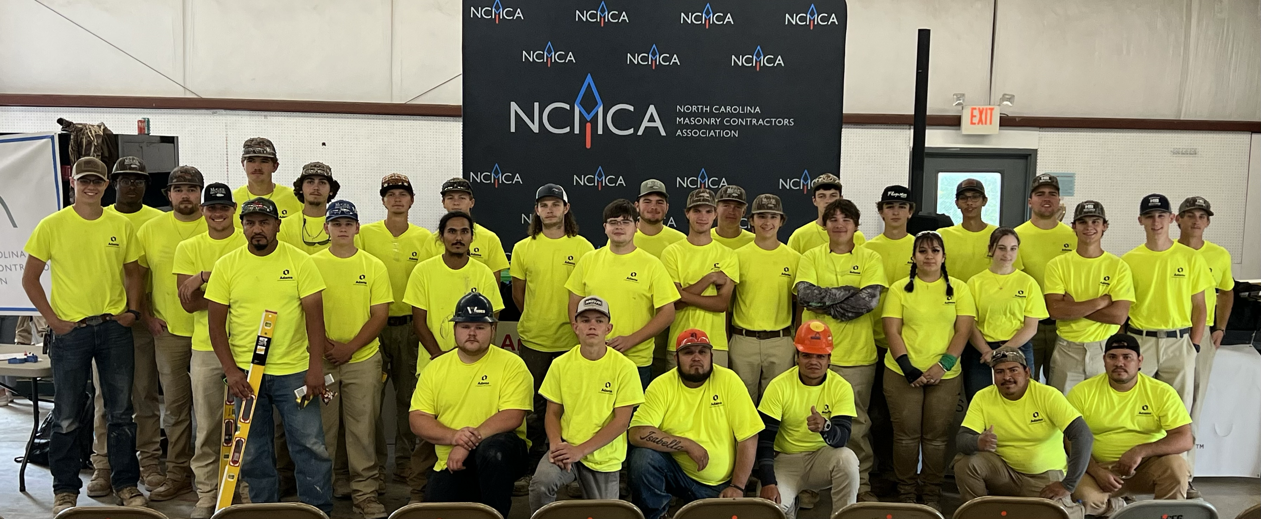 Large group of masonry students in NCMCA shirts at a skills contest